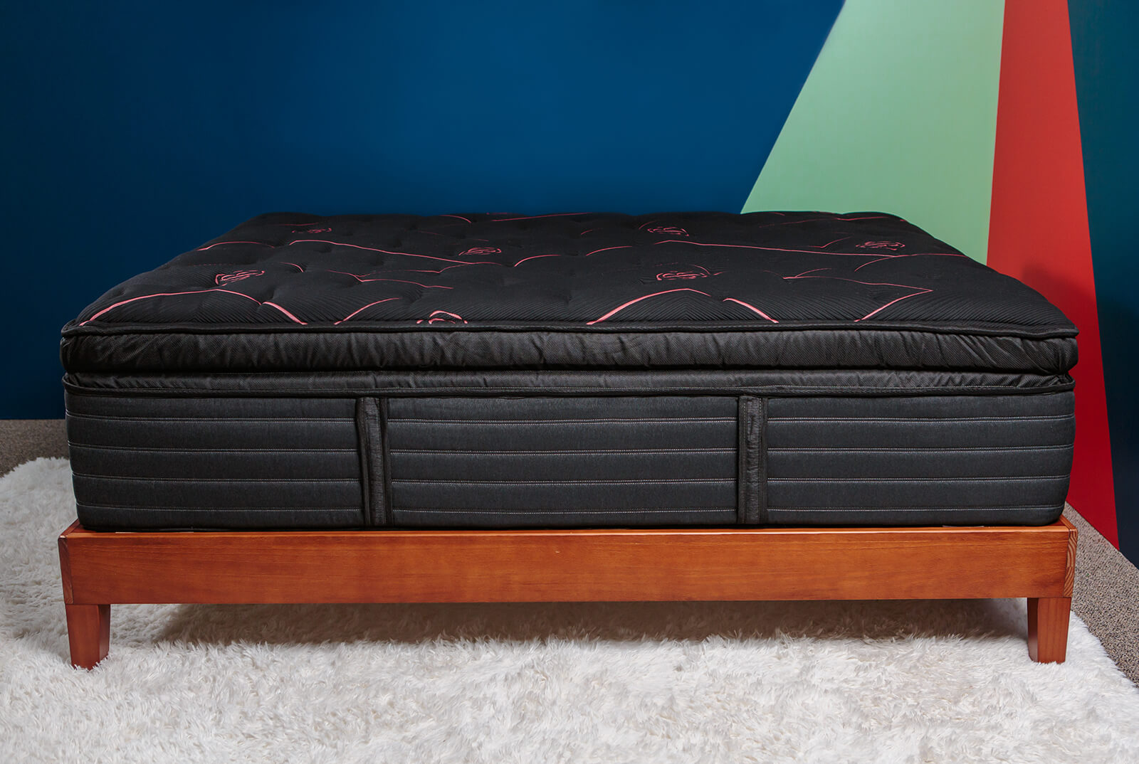 Photo of the Beautyrest Black Signature Mattress on a bedframe in a bedroom taken from a side angle.