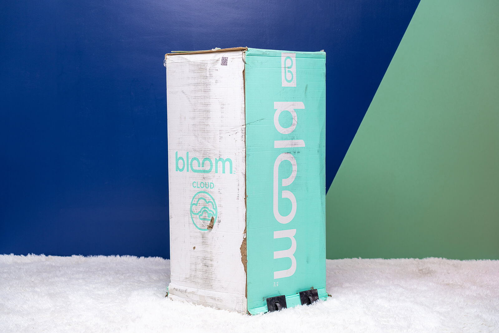 Photo of the Bloom Cloud box on the floor in a bedroom taken from a front angle.