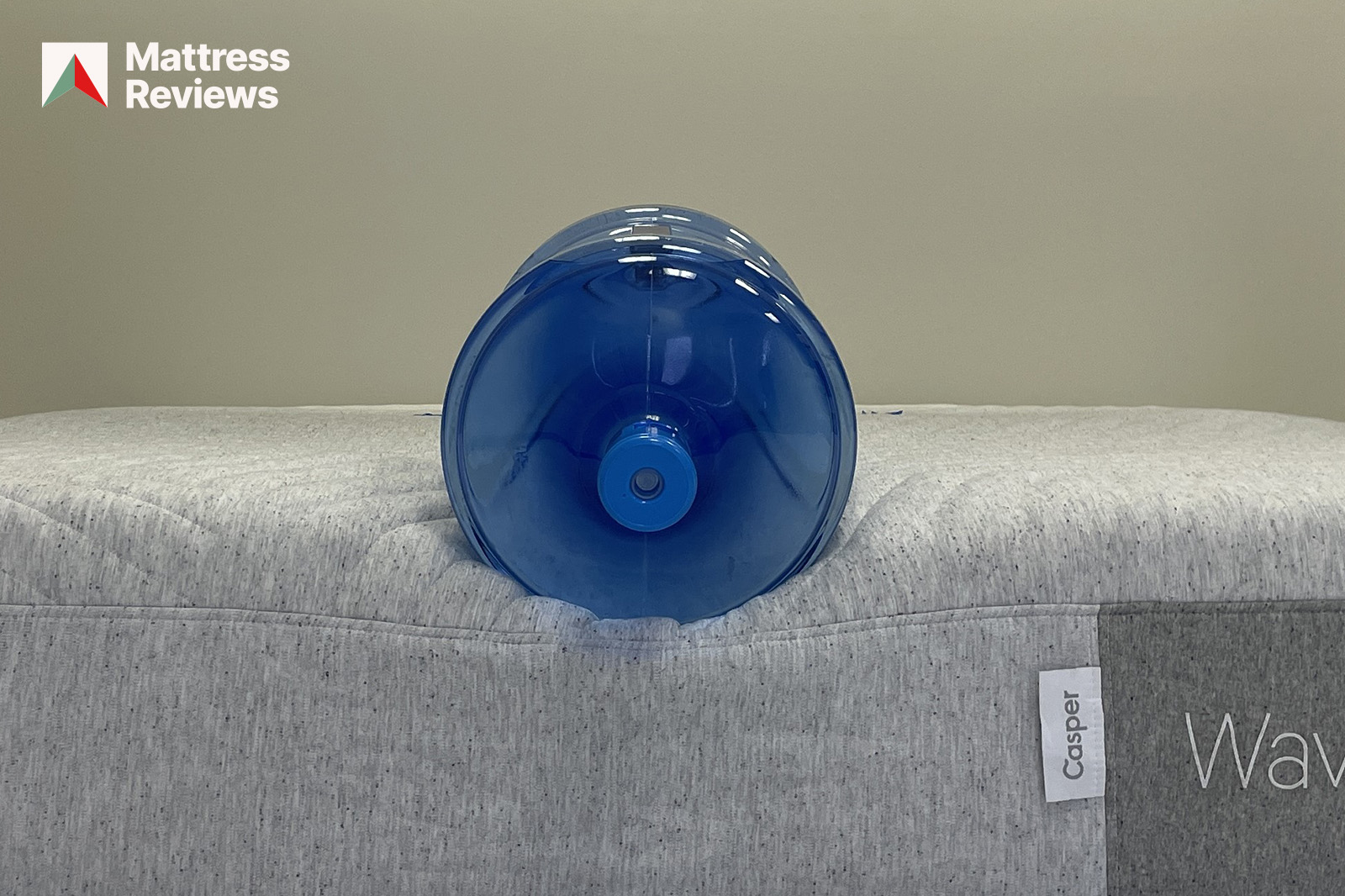 Photo of a water jug sitting on the edge of the Casper Wave Hybrid mattress to demonstrate edge support