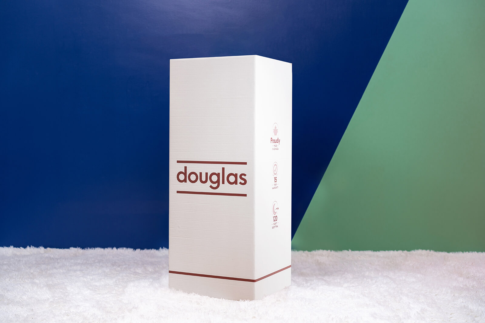 Photo of the Douglas Alpine Mattress box on the floor in a bedroom taken from a front angle.