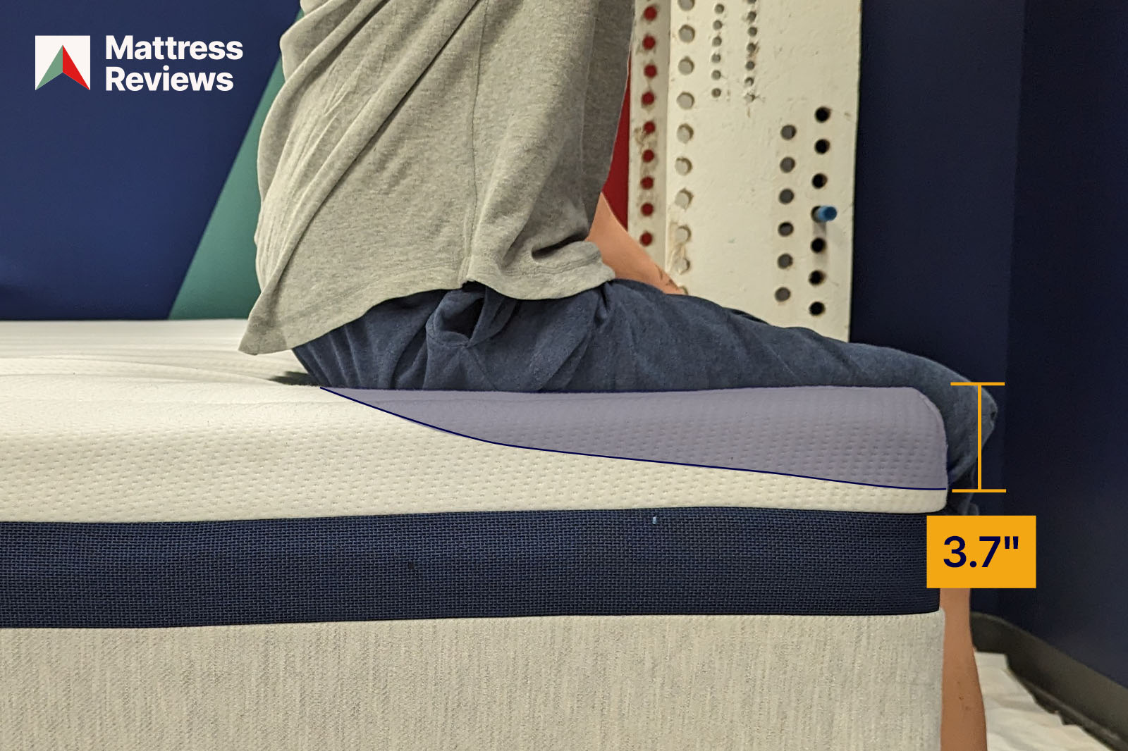 photo of a mannequin sitting on the edge of the Helix Midnight mattress showing a displacement of 37