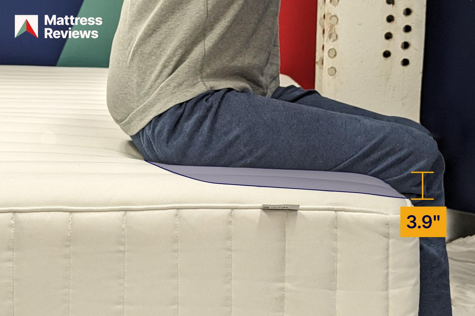 photo of a mannequin sitting on the edge of the IKEA Valevag mattress showing a displacement of 39
