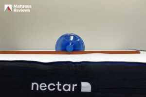 Photo of a water jug and a level on top of the Nectar mattress to demonstrate firmness