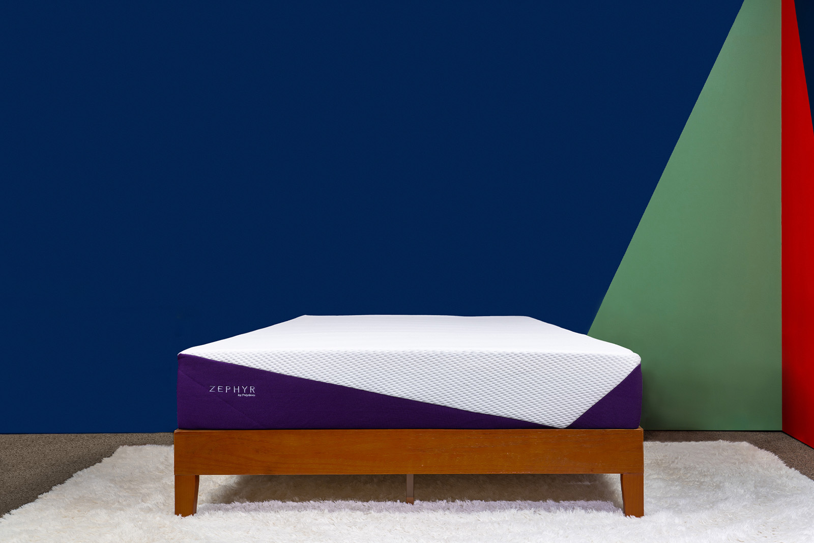 Photo of the Polysleep Zephyr mattress on a bed frame in a bedroom taken from a front angle.