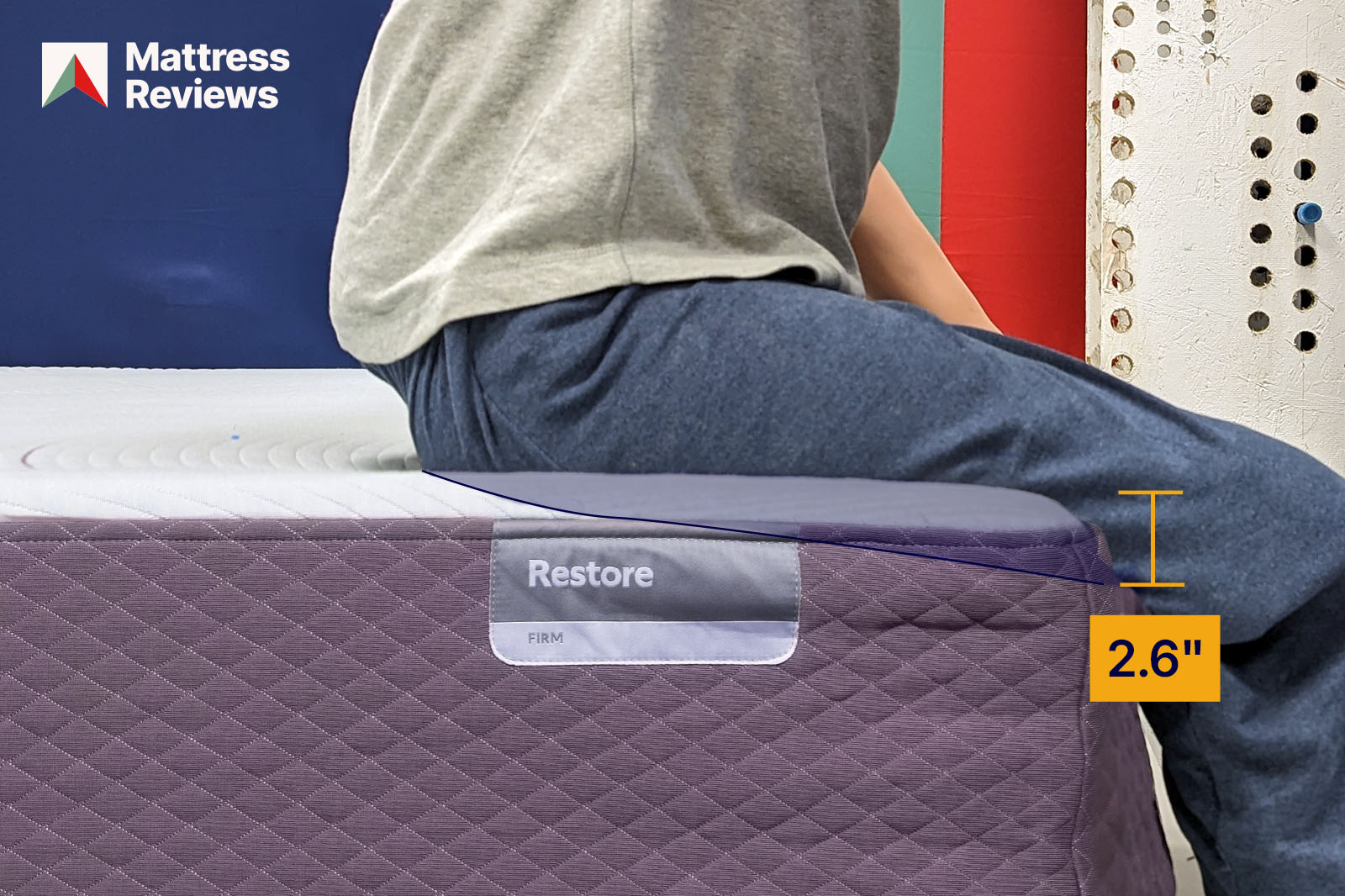 Photo of a mannequin sitting on the edge of the Purple Restore Hybrid mattress leaving an impression to demonstrate the amount of edge support