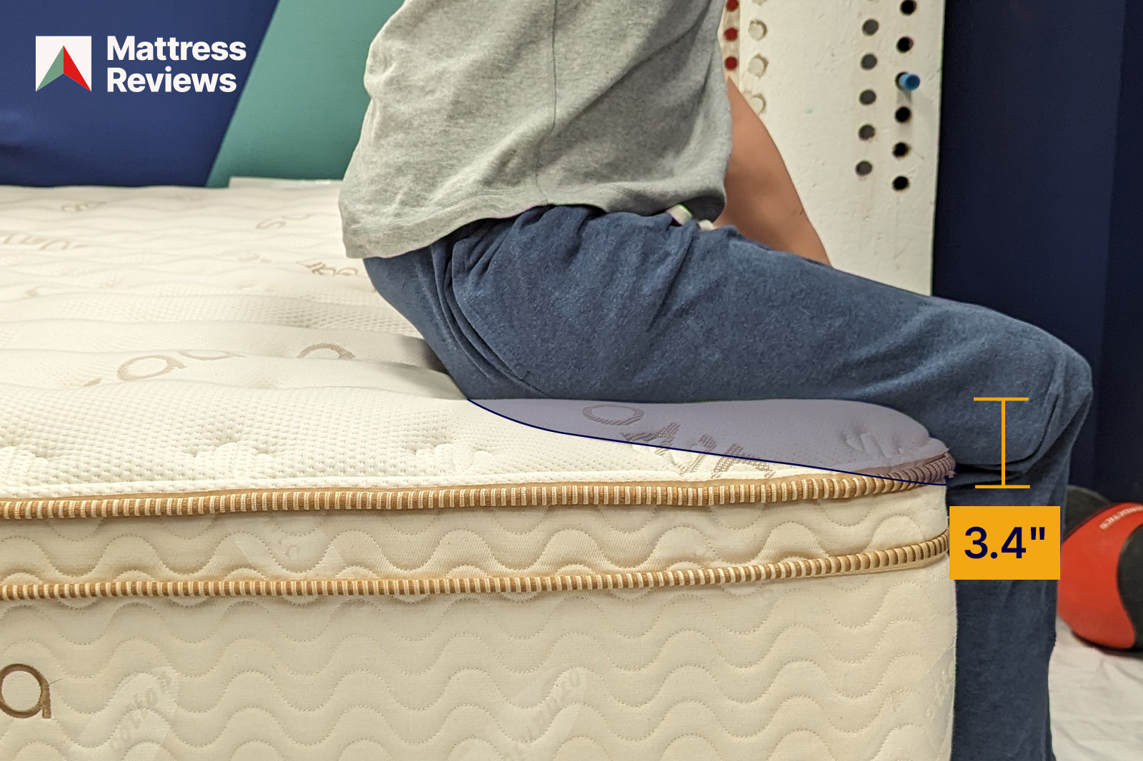 Image of a mannequin sitting on the edge of the Saatva Classic mattress leaving an impression that indicates the amount of edge support