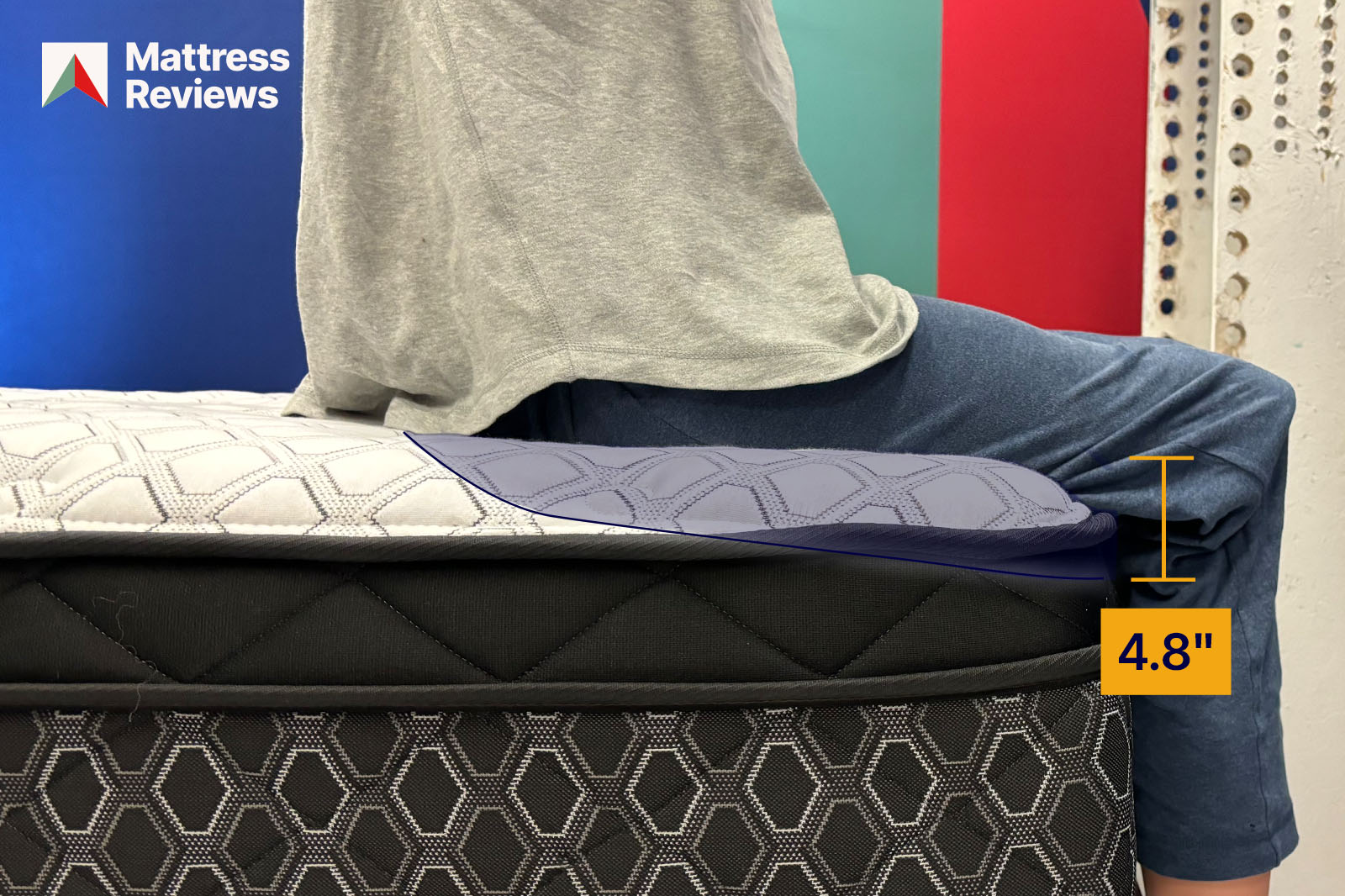 Photo of a mannequin sitting on the edge of the Sealy Posturepedic Hollycourt mattress to demonstrate edge support