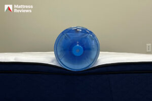 Phot of a water jug sitting on the edge of the Silk Snow Hybrid mattress to demonstrate edge support